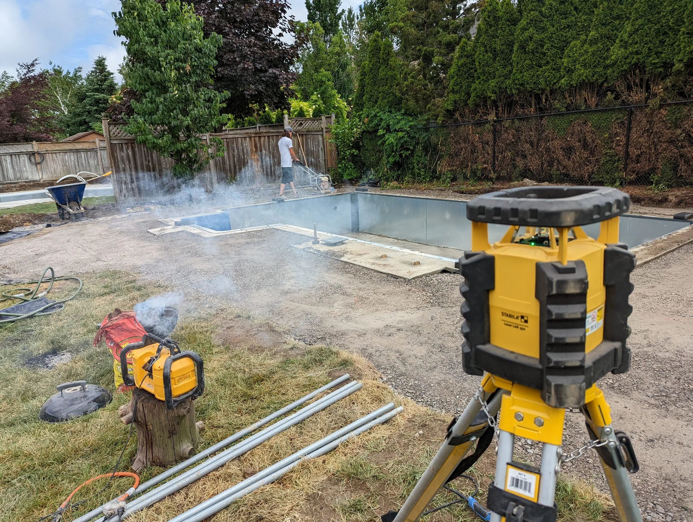 Compaction equipment preparing a hardscape base on a job site