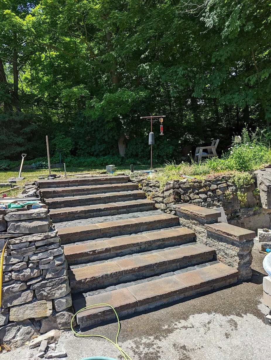 Stone steps and landing connected to a residential entrance.