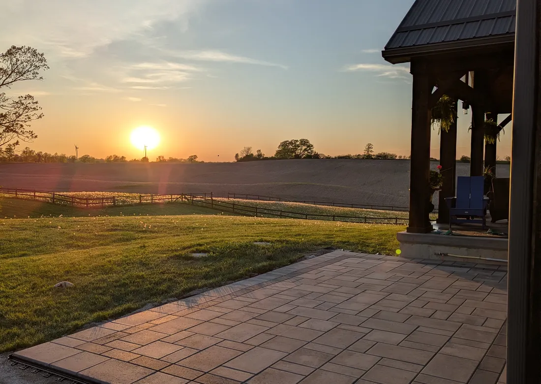 A beautiful modern patio overlooking rolling hills and a sunset