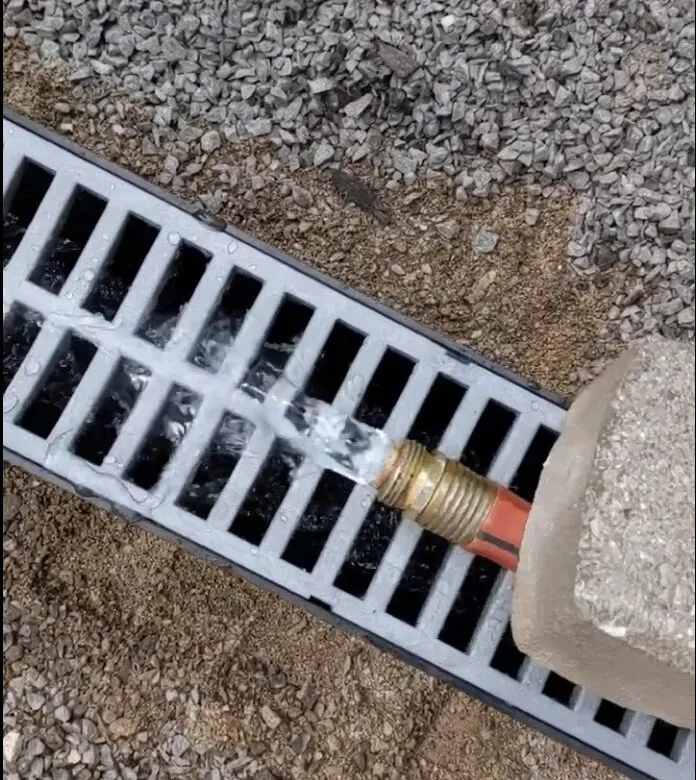 Drainage materials and grading conditions used to review runoff around hardscape work.