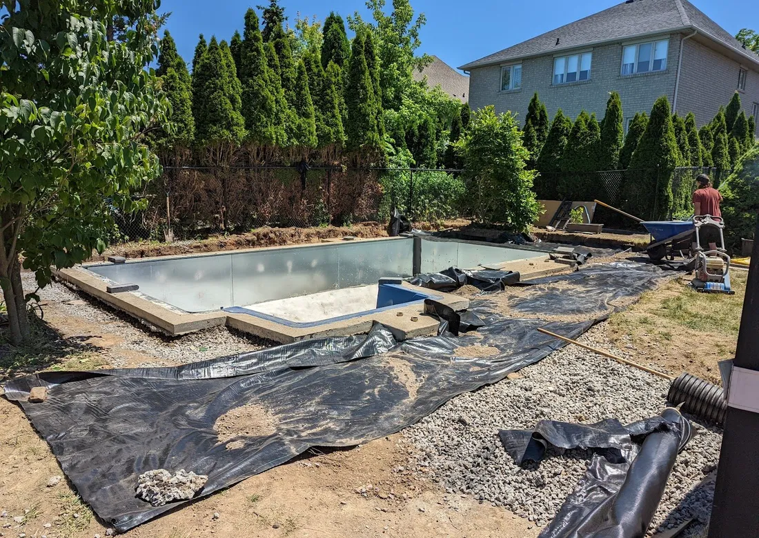A pool under construction with geotextile being laid alongside its permiter