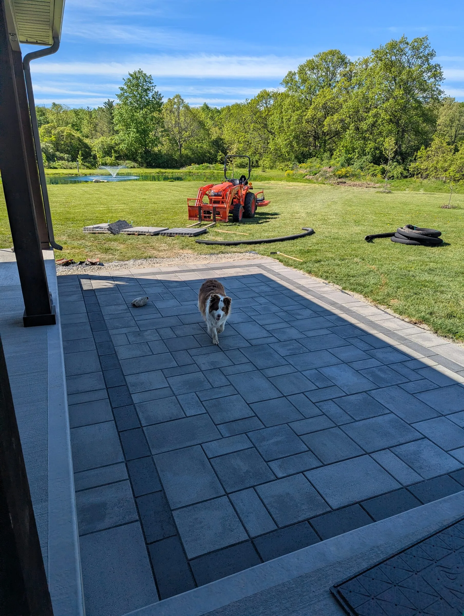 Worker maintaining a contained hardscaping work area near a home