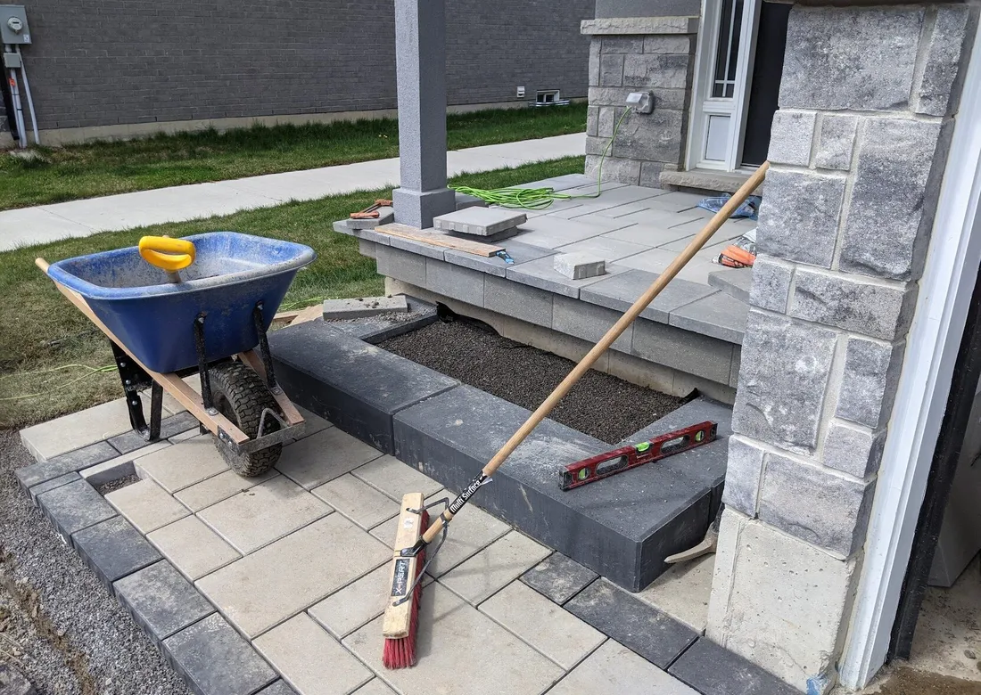 A modern walkway & steps loading to a front landing with interlock, caps and risers.