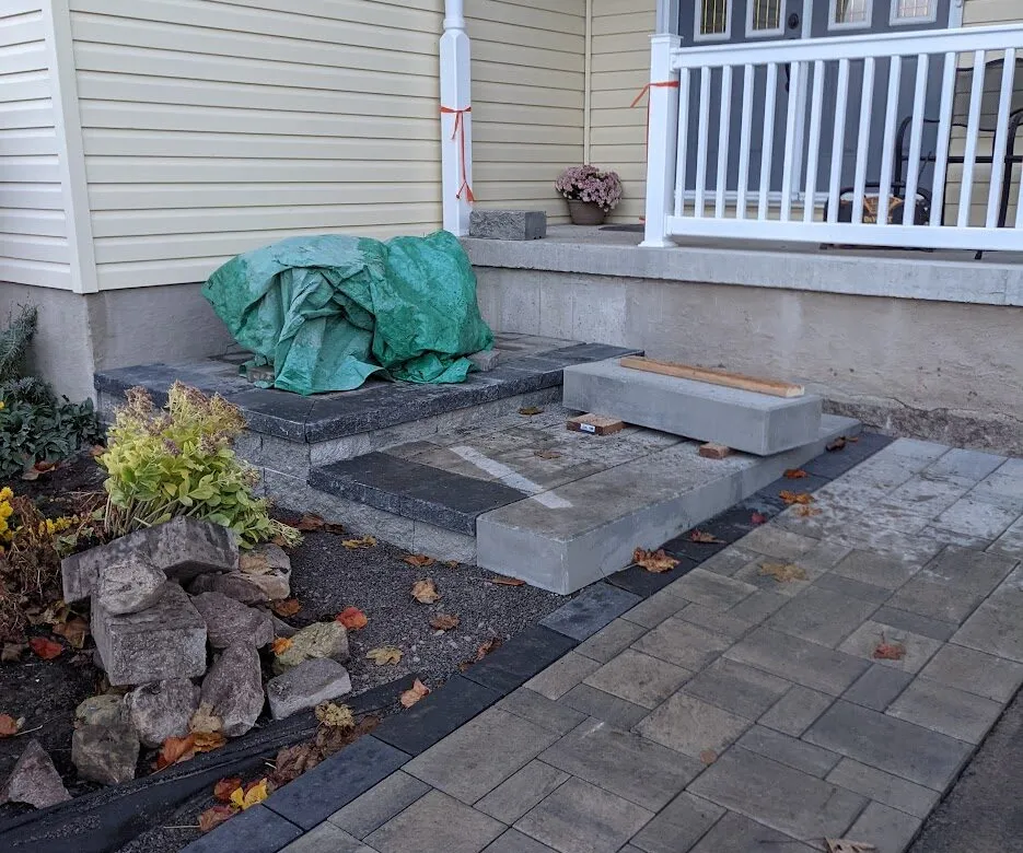 An interlock walkway leading to natural looking stone walls and steps
