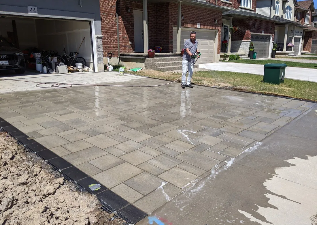A driveway being watered down by some chemically reacting chemical, with lights being taped over