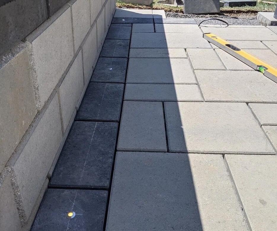 A black border running alongside a modern wall system, with modest lights installed