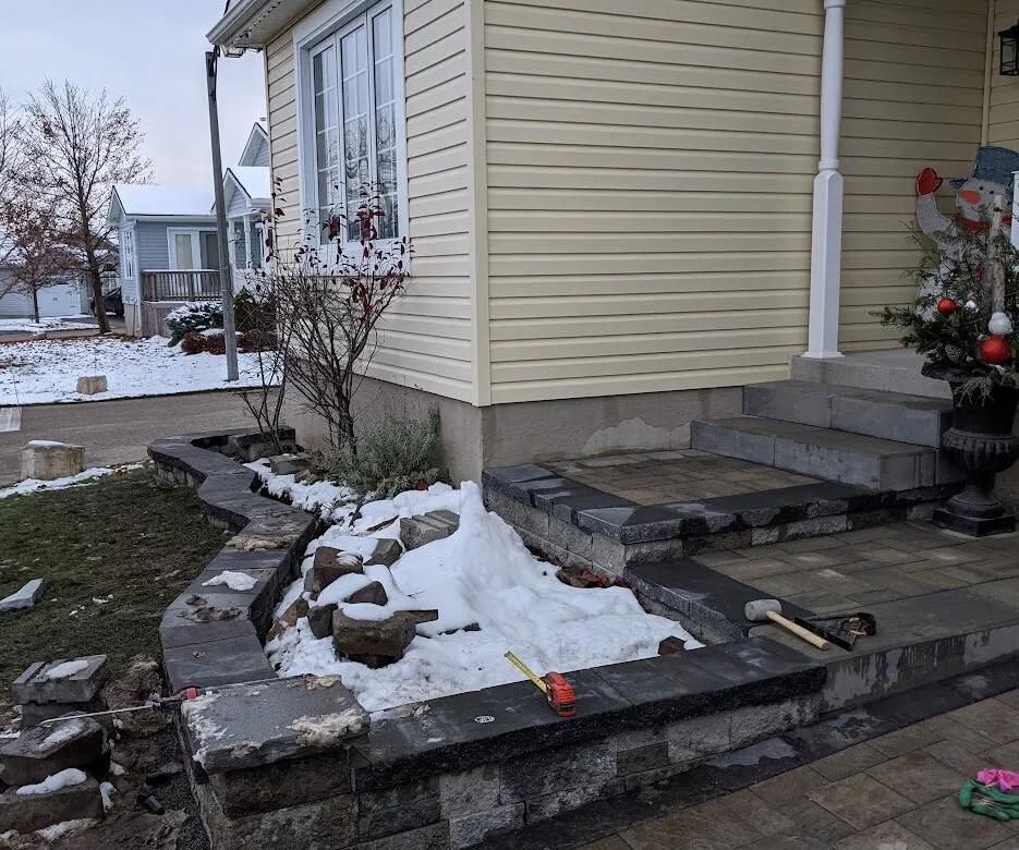 A beautiful walkway, garden wall, front landing and steps covered by snow